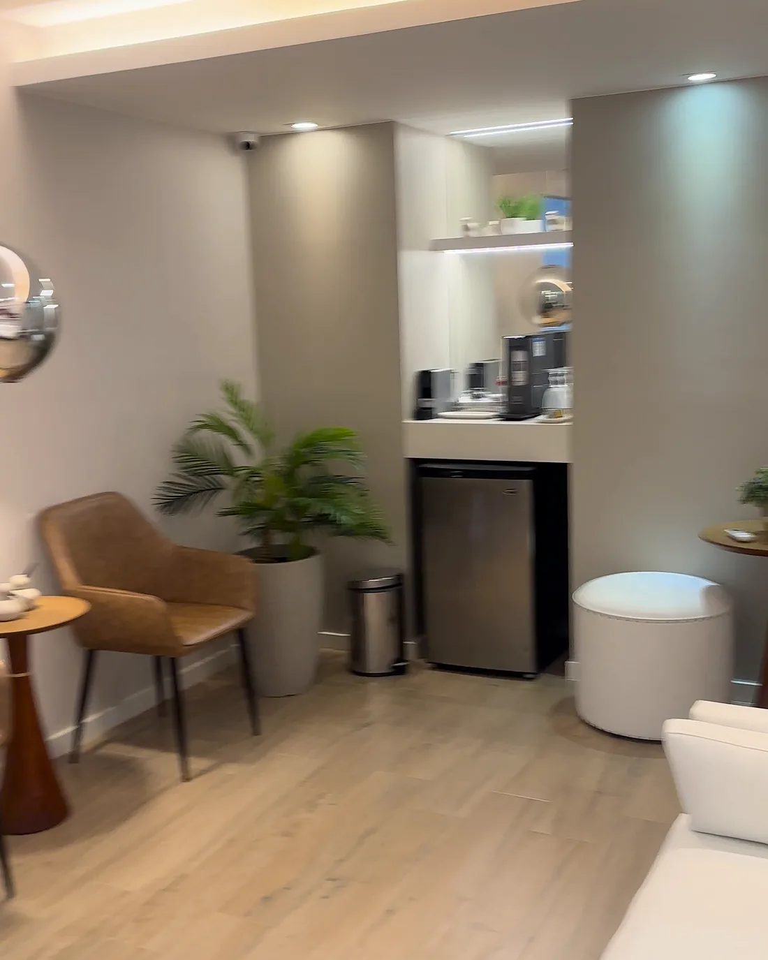 Sala de espera com poltronas, planta e copa